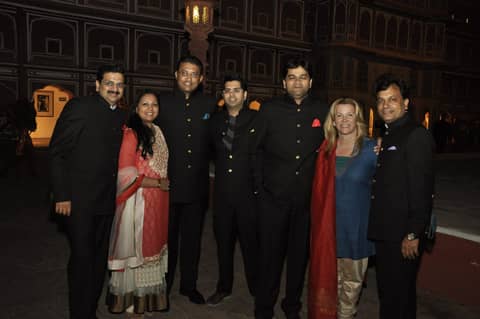 Small group of six in front of lit palace facade