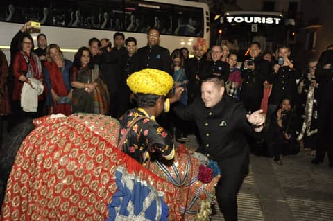 Costumed folk performers welcoming guests by tourist bus