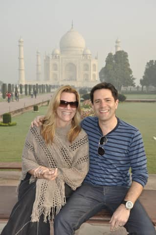 Same couple seated in front of the Taj