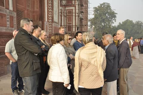 Group of visitors outside a red sandstone monument