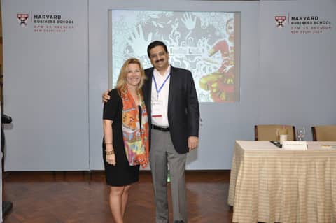 Gayle and man with lanyard standing by projection screen
