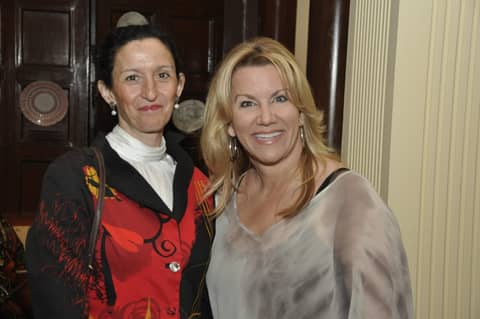 Two women posing, one in red, one blonde in grey