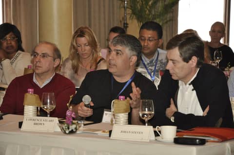 Classmates at a session table, one woman with microphone behind