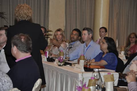 Session from behind a speaker, classmates at tables