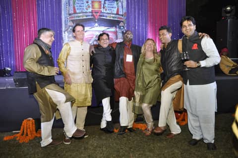 Group of seven in Indian dress posing on stage