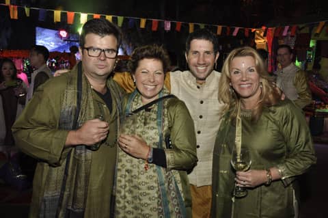 Four in Indian dress, festive lights behind
