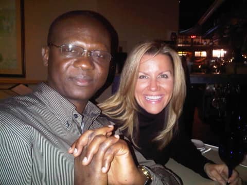 Close two-shot: Gayle in black turtleneck smiling with man in striped shirt