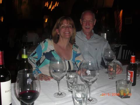 Woman in patterned top and older man at restaurant table
