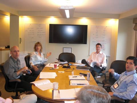 Meeting room: group at round table with flipcharts and TV